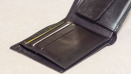 Open black leather wallet on a light background