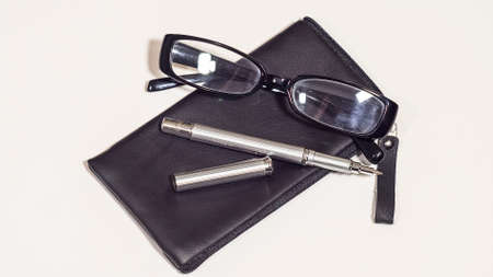 Leather black cover, bussines glasses and metal pen