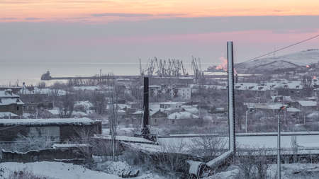 Snow-covered factory, the city, and the morningの写真素材