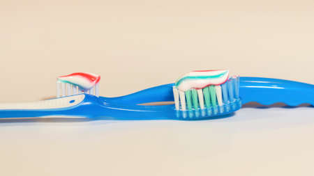 Two toothbrushes with colorful brush on light gray backgroundの写真素材