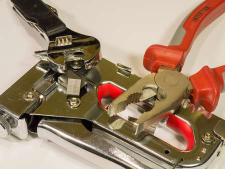 Stapler, pliers, wrench on a light background