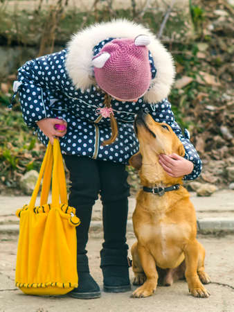 The girl hugging and looking at a dogの写真素材