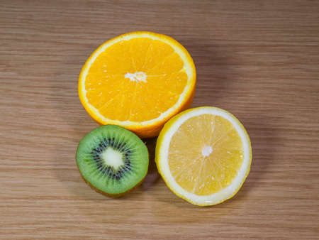 The lemon, orange and kiwi on a wooden surfaceの写真素材