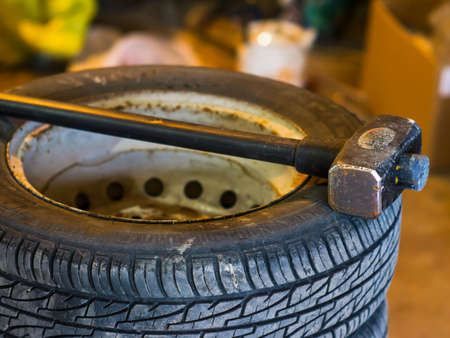 A large sledgehammer on the wheel of a carの写真素材