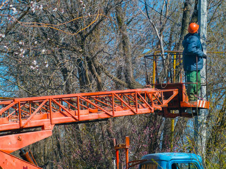 A worker on the stairs removes ragged wires