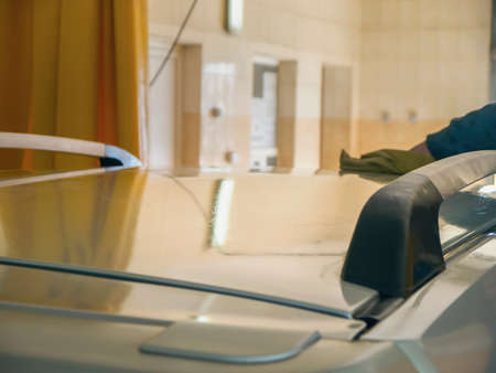 The worker at the car wash wipes the car with a ragの写真素材