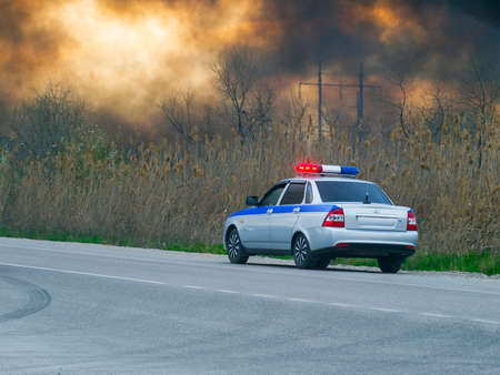 A police car by the roadside. The sky is in the smoke.の写真素材