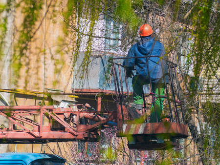Worker in special clothes on the lift machineの写真素材