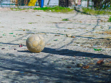 An old soccer ball on a dirt soccer fieldの写真素材