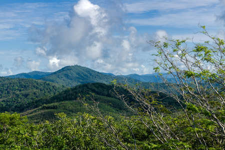 The landscape of the mountain ridge of Phuket and the Adaman Sea against the background of a blue sky with clouds.の写真素材