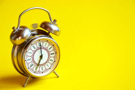 The old alarm clock rings on an isolated yellow background.の写真素材