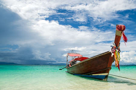 Beautiful seascape with azure water of the Adaman Sea with blue sky and clouds. Traditional boats:...