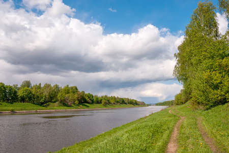Spring landscape. Green foliage and blue sky with clouds Canal named after Moscow