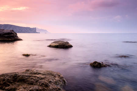 Morning seascape. Sea water at long exposure, stones and rocks. Beautiful sky with clouds.の写真素材
