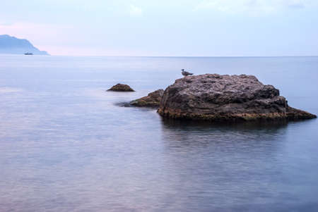 Morning seascape. Sea water at long exposure, stones and rocks. Beautiful sky with clouds.の写真素材