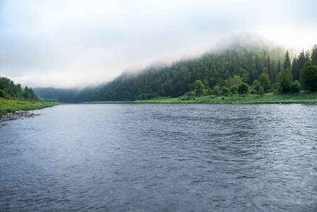 Landscapes of Siberia. Early morning on the Kiya river. Fog descends on the river over the taiga. Kemerovo region.の写真素材