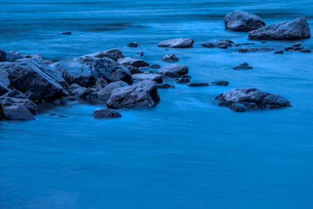 Mountain River. Stones and blue water on a long shutter speed.