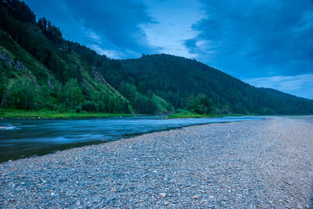 Landscapes of Siberia. Evening landscape at sunset. Mountains, forest, river and water at long...