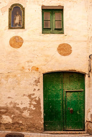 A wooden vintage window and a door on a plastered stone wall in the Spanish style.の写真素材