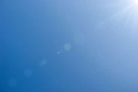 Blue summer sky with bright sun as backgroundの写真素材