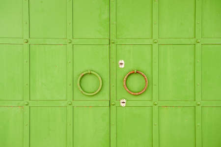 Green door with round steel ring (door handle).の写真素材