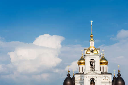 Uspensky Cathedral in the Dmitrovsky Kremlin, against the background of a blue sky with clouds....