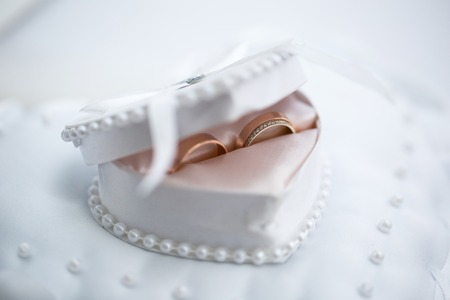 Wedding rings in a white heart-shaped jewelry box