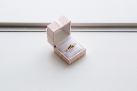 Gold ring with a precious stone in a pink jewelry boxの写真素材