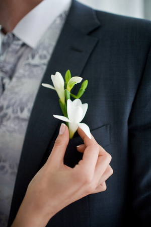 Fuchsia boutonniere on the background of the grooms jacketの写真素材