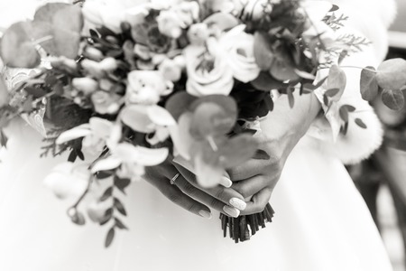 Exquisite wedding bouquet in the hands of an unrecognizable bride, black and white shotの写真素材