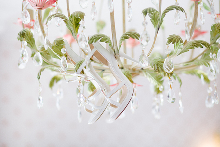 White high heels on a colored crystal chandelierの写真素材