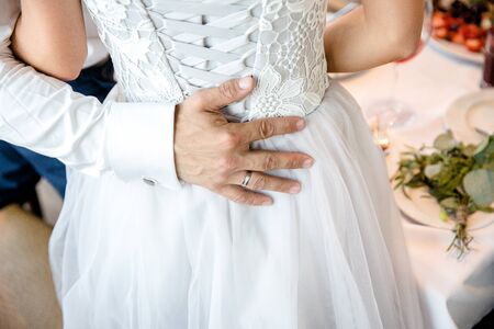 The groom hugs the bride. The hand of the groom on the back of the bride.の写真素材
