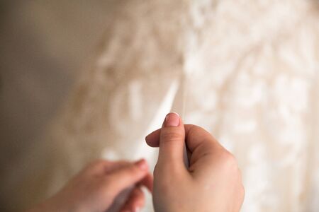 Bride from the back. The bridesmaid laces the wedding dress.の写真素材