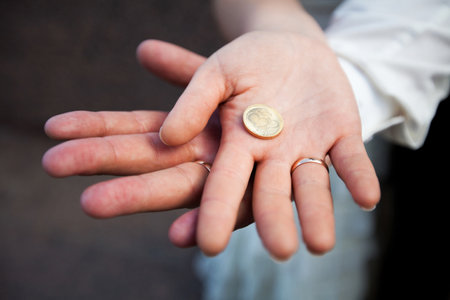 Bride and Grooms Hands Together Holding a Coin with Heart Symbol Close-Up