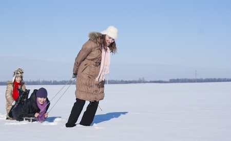 Two happy sisters sledding at winter timeの写真素材