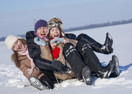 Two happy sisters sledding at winter timeの写真素材