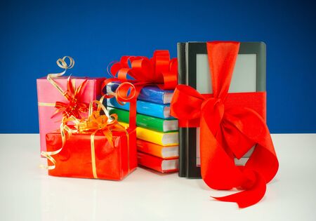 Christmas presents with electronic book reader against blue backgroundの写真素材
