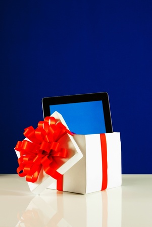 Tablet PC in a gift box against blue backgroundの写真素材
