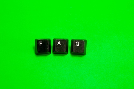Three plastic keys with FAQ word over green backgroundの写真素材