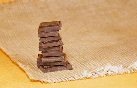 Chocolate stacked into bar isolated over yellow backgroundの写真素材