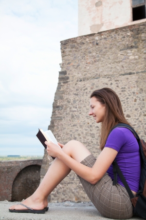 Teen girl reading the Bible sitting outdoorsの写真素材