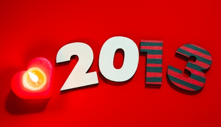 Wooden 2013 year number with a burning candle over red backgroundの写真素材