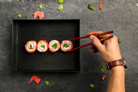 Traditional Japanese cuisine, sushi rolls on a black plate, view from the topの写真素材