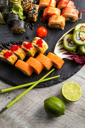 Various kinds of sushi served on black stone. Sushi Set sashimi and sushi rolls, top viewの写真素材