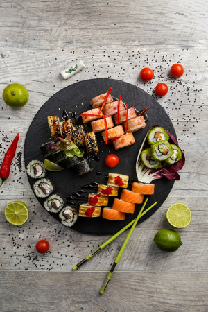 Various kinds of sushi served on black stone. Sushi Set sashimi and sushi rolls, top viewの写真素材
