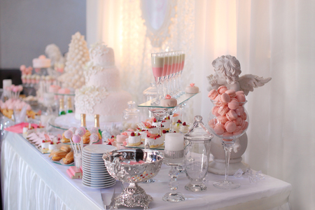 Dessert table for a party. Ombre cake, cupcakes, sweetness and flowersの写真素材