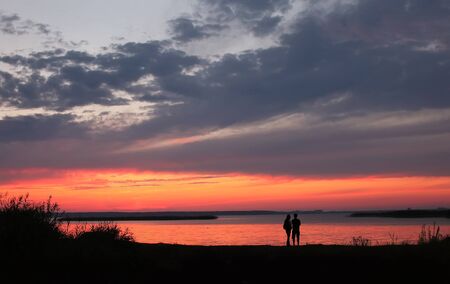 Couple at Beach on Sunset Backgroundの写真素材