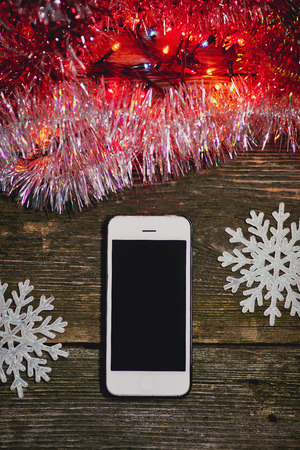 Christmas toys and white smartphone on a wooden background.の写真素材
