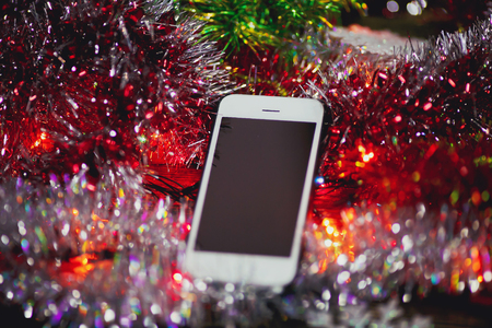 Christmas toys and white smartphone on a wooden background.の写真素材