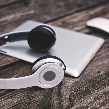 Tablet computer with headphones against wooden backgroundの写真素材